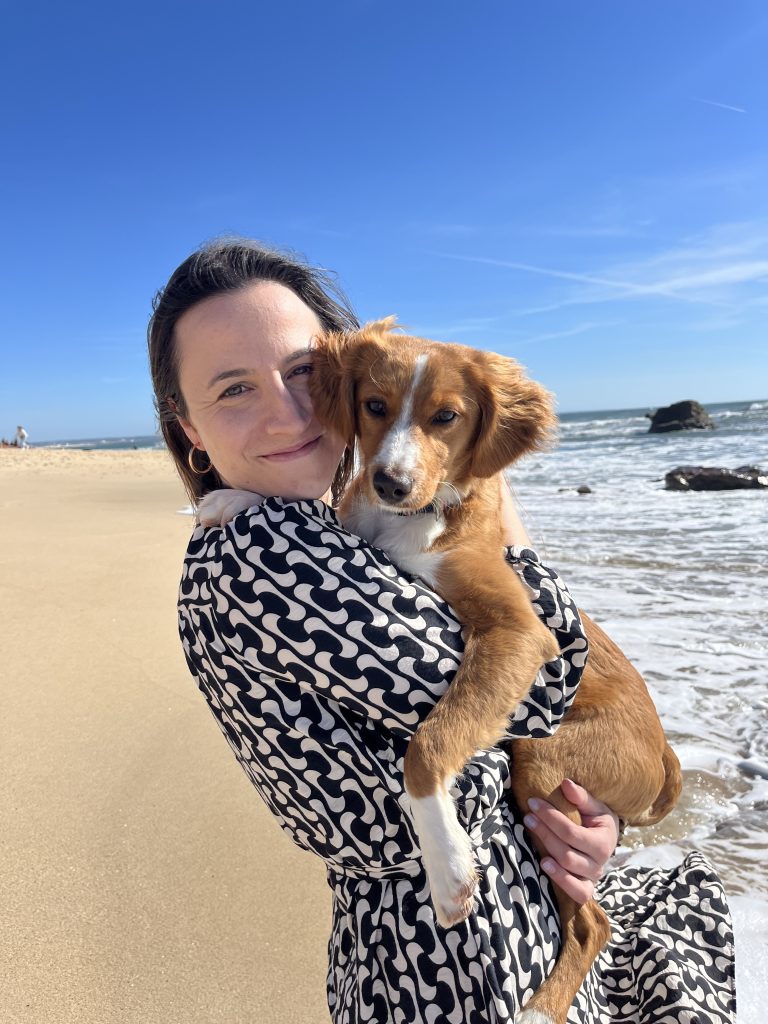 girl holding puppy at the beach